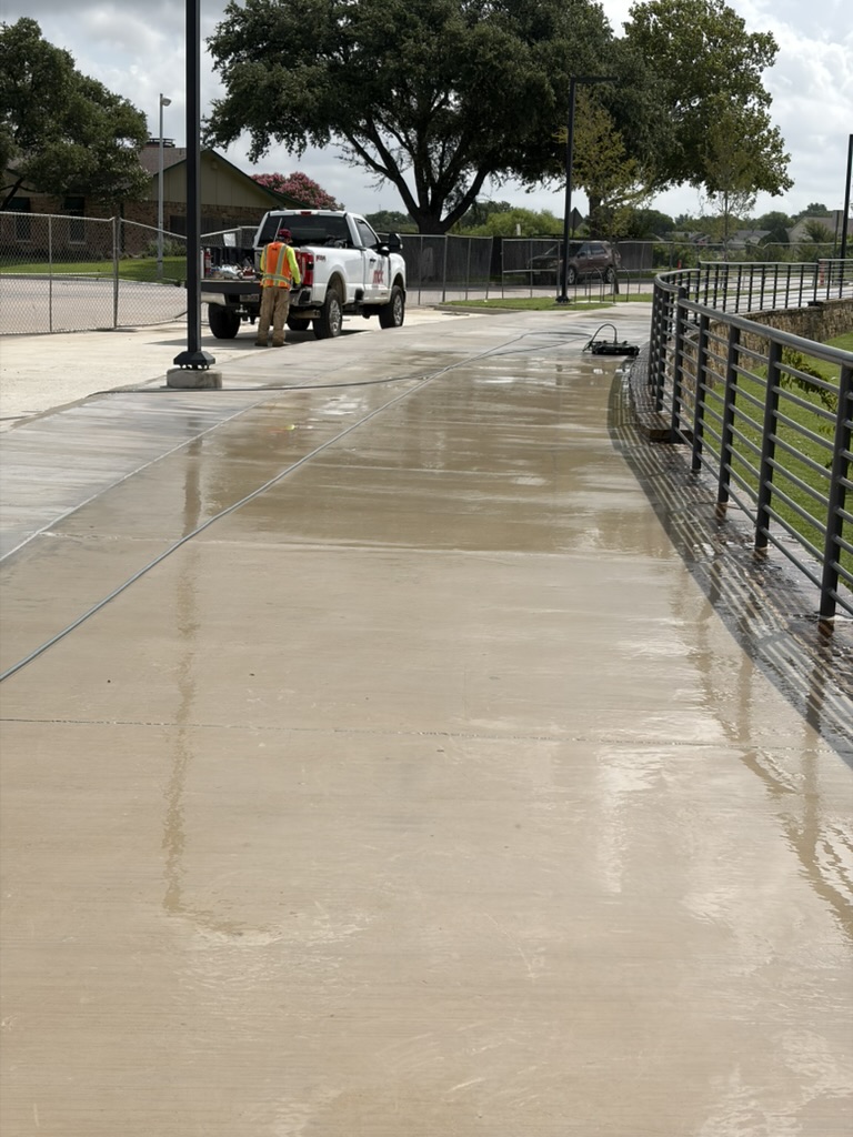 High-school walkway after pressure cleaning, with buildup removed from concrete
